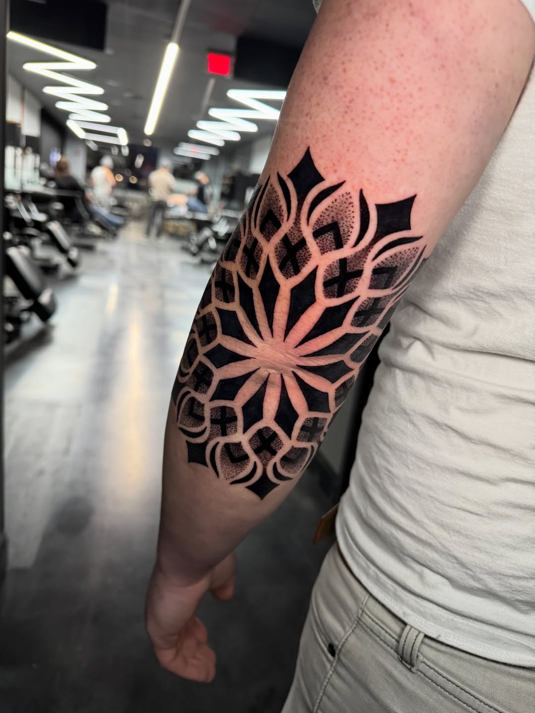 Bold Geometric Mandala Forearm Tattoo with Heavy Blackwork