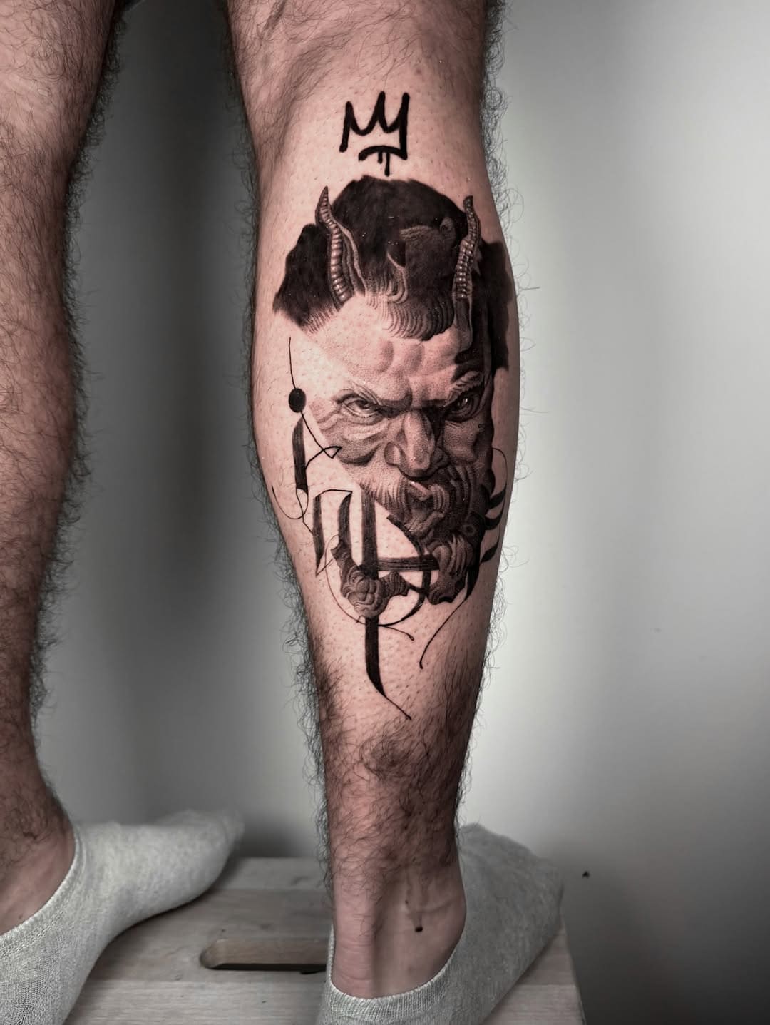 Tatouage de portrait démoniaque sombre sur le mollet