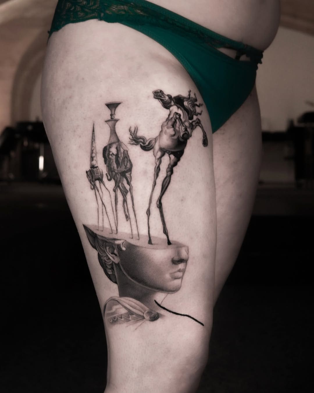 Tatouage d’un buste classique surréaliste avec des figures oniriques inspirées de Dalí
