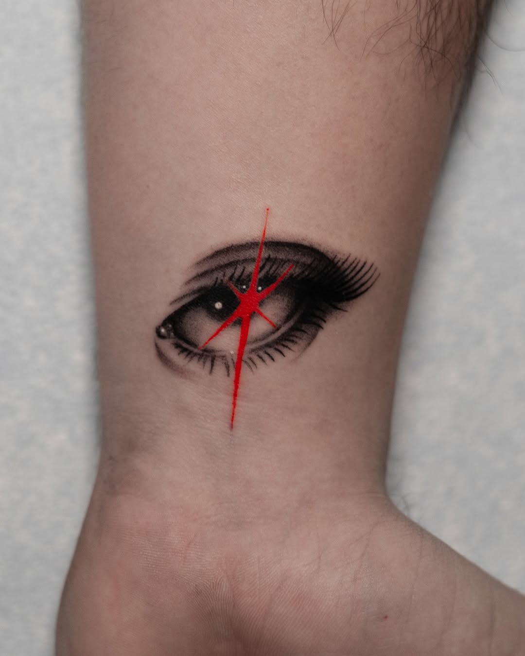 Stylized Realism Eye Tattoo with Red Star Accent