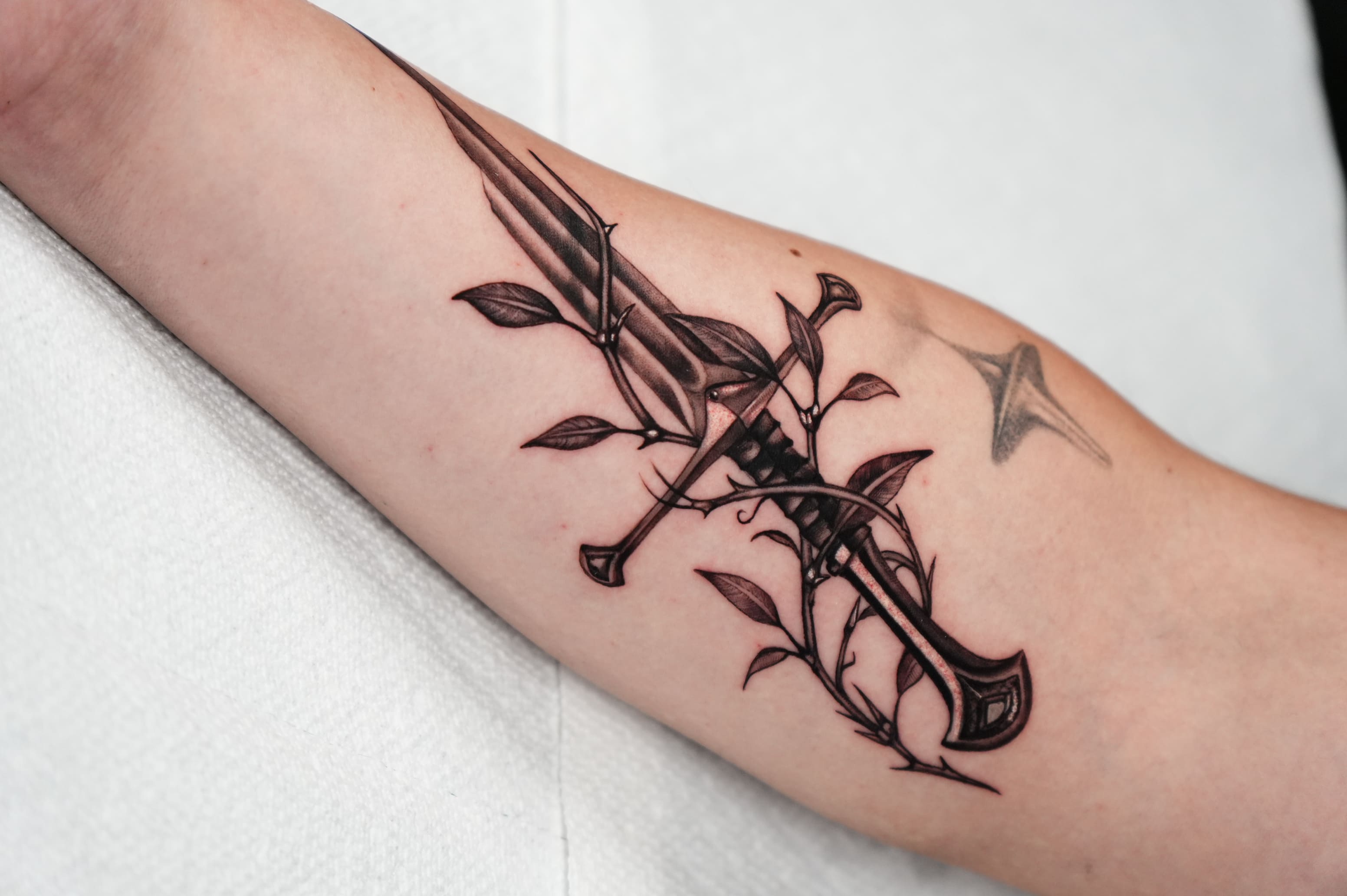 Thorn-Wrapped Sword Forearm Tattoo