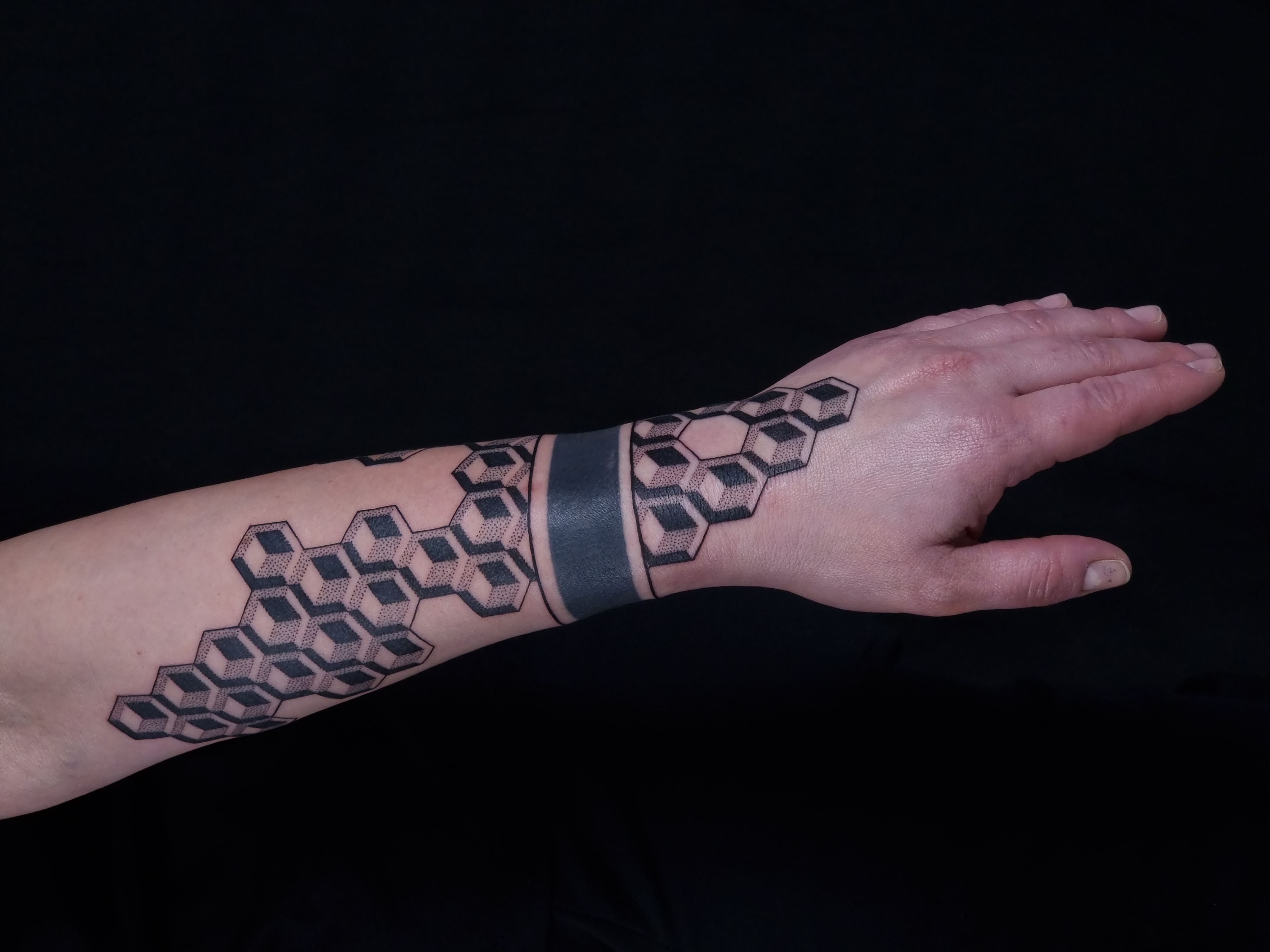 Geometryczny tatuaż 3D na ręce – wzór kostek