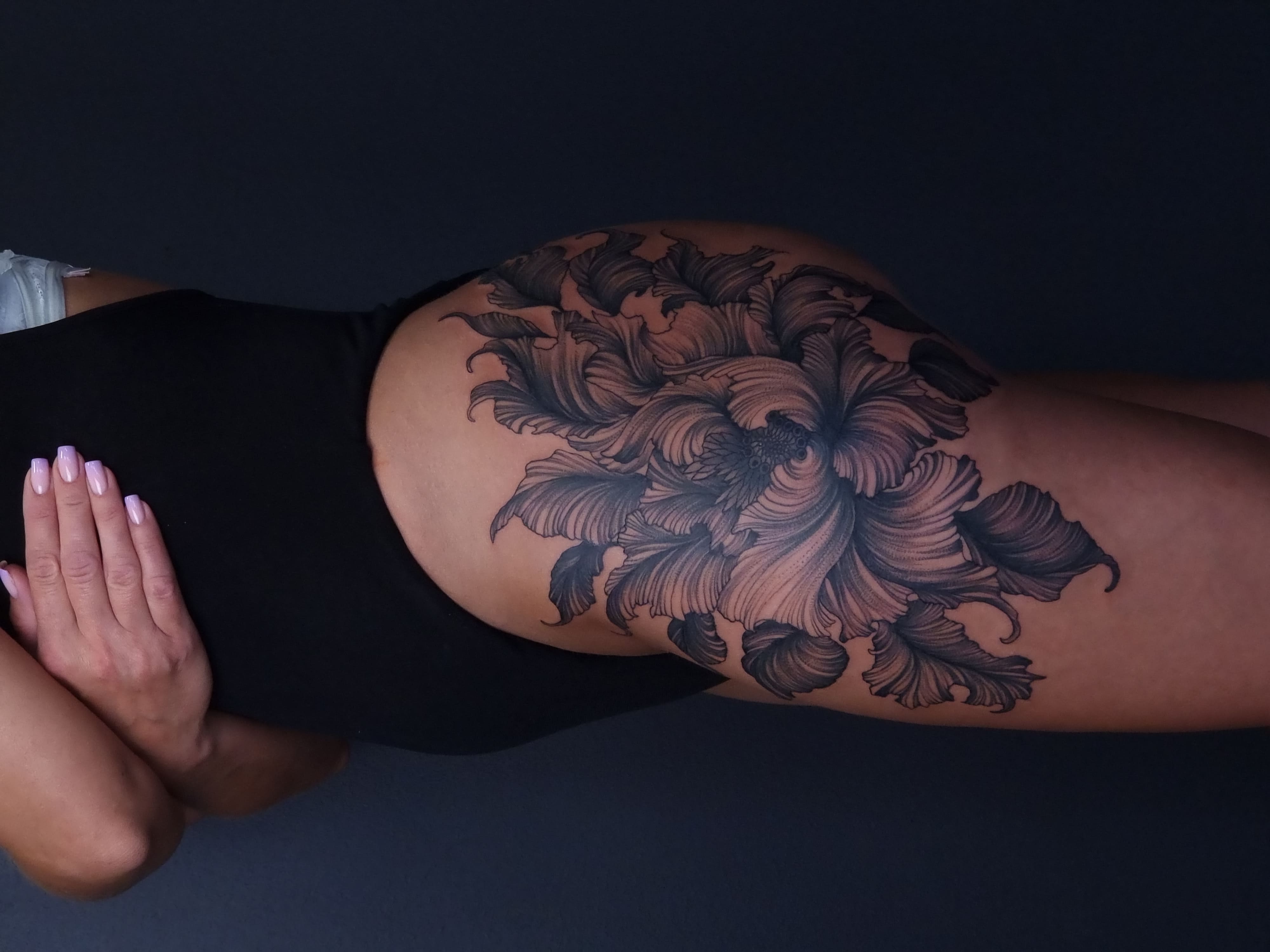 Kwiatowy tatuaż na biodrze – duża realistyczna kompozycja