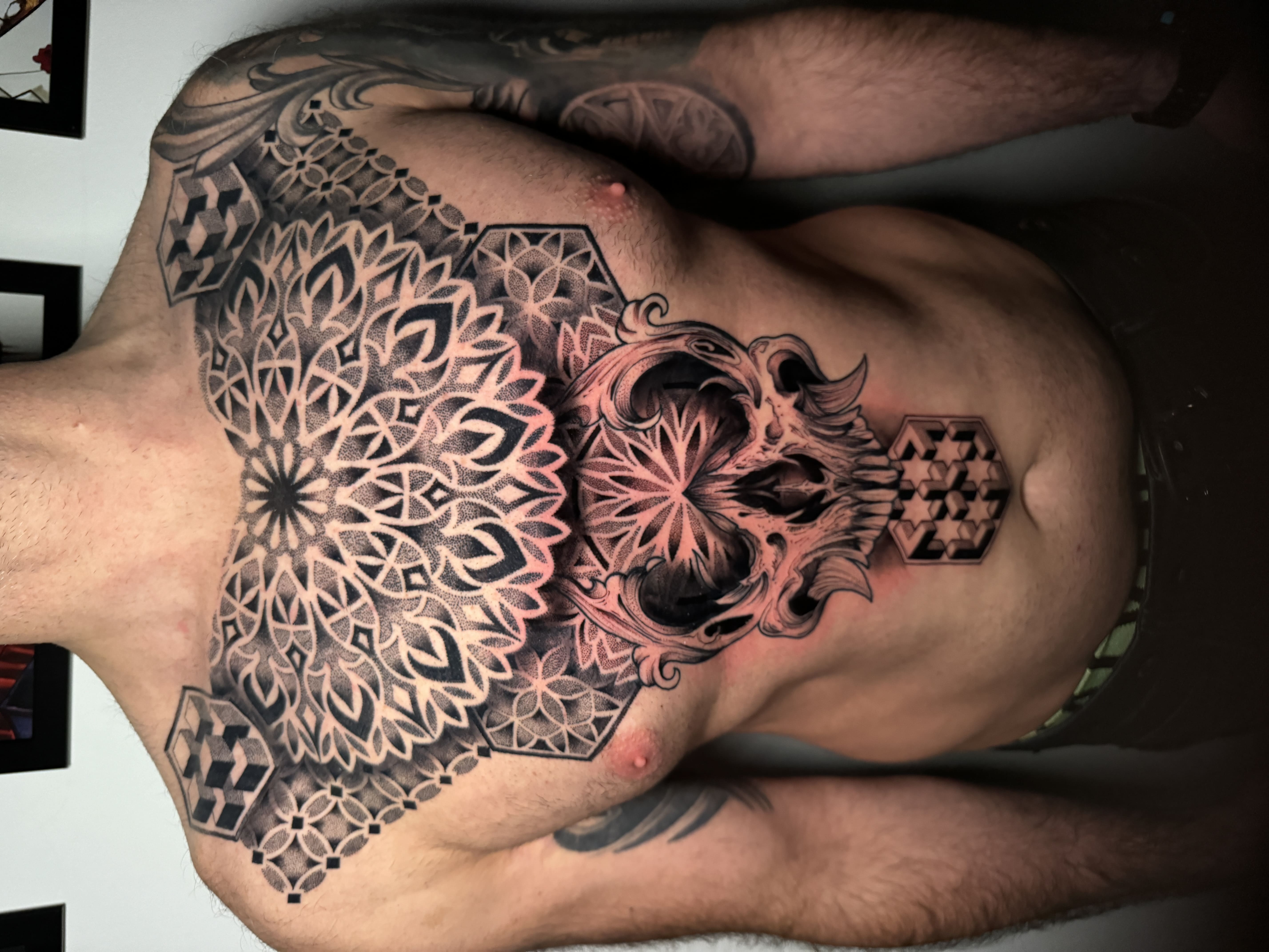 Geometriczna mandala i czaszka – kompozycja na klatce piersiowej